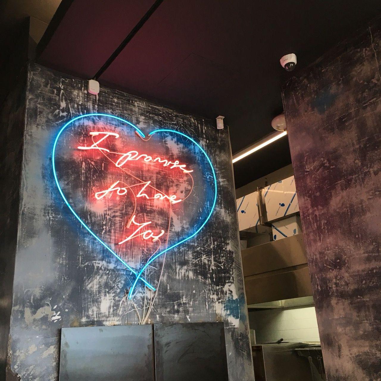 A neon heart sign inside Café Mônsant in Jeju Island, creating a trendy, urban feel.
